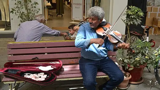 Sokakta keman eşliğinde türküler söylüyor